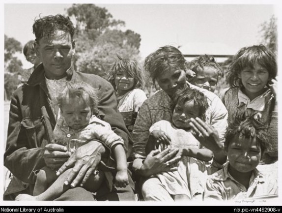 The Michaels family, Pingelly, 1938. From left to right Beth (behind), Jack Michael, Vera (held by Jack), Amy (behind), Eva Michael nee Humes, Nora (held by Eva), Mervyn (back), Albert (front), Marjorie (back). Photographer: Axel Poignant. Permission Marjorie Nelson, nee Michael (back right in photo); Roslyn Poignant on behalf of Axel Poignant; National Library of Australia nla.pic-vn4462908