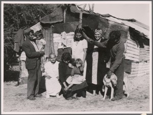 Mrs Worrall and family, 1951. From left: Charlie Nettle (son-in-law) carrying a toddler; Mrs Worrall; Mrs Hedland Jr. (daughter) holding child; Mrs C Nettle (daughter); Doris Mippy (granddaughter); Billy Worrall (son). Courtesy Argus Collection of Photos, State Library of Victoria, H2002.199/87. Photographer Ronald H Armstrong